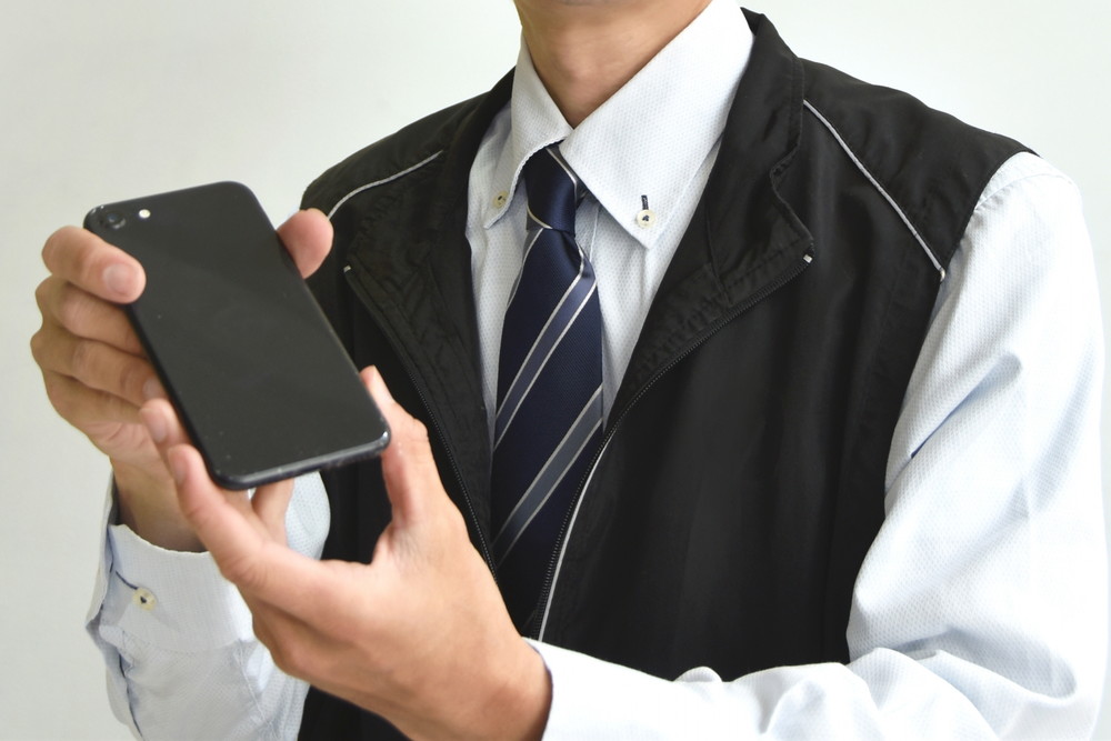 家電量販店の店員-スマホを差し出す