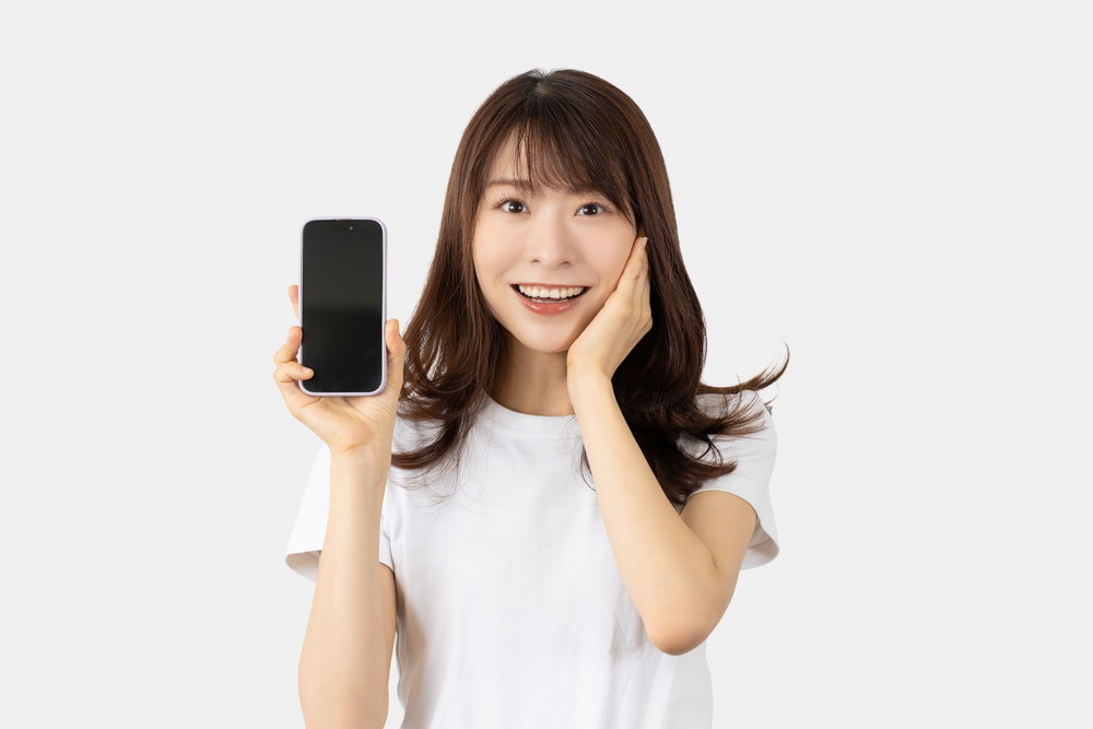 スマホを持って驚き喜ぶ女性