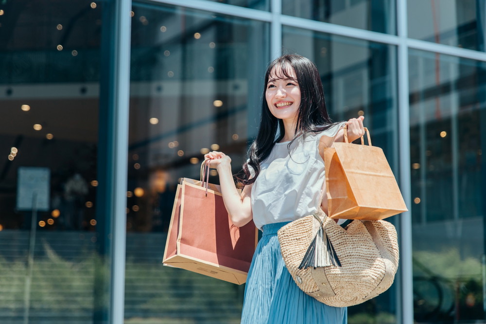 ショッピングモール-両手に買い物袋を抱える女性